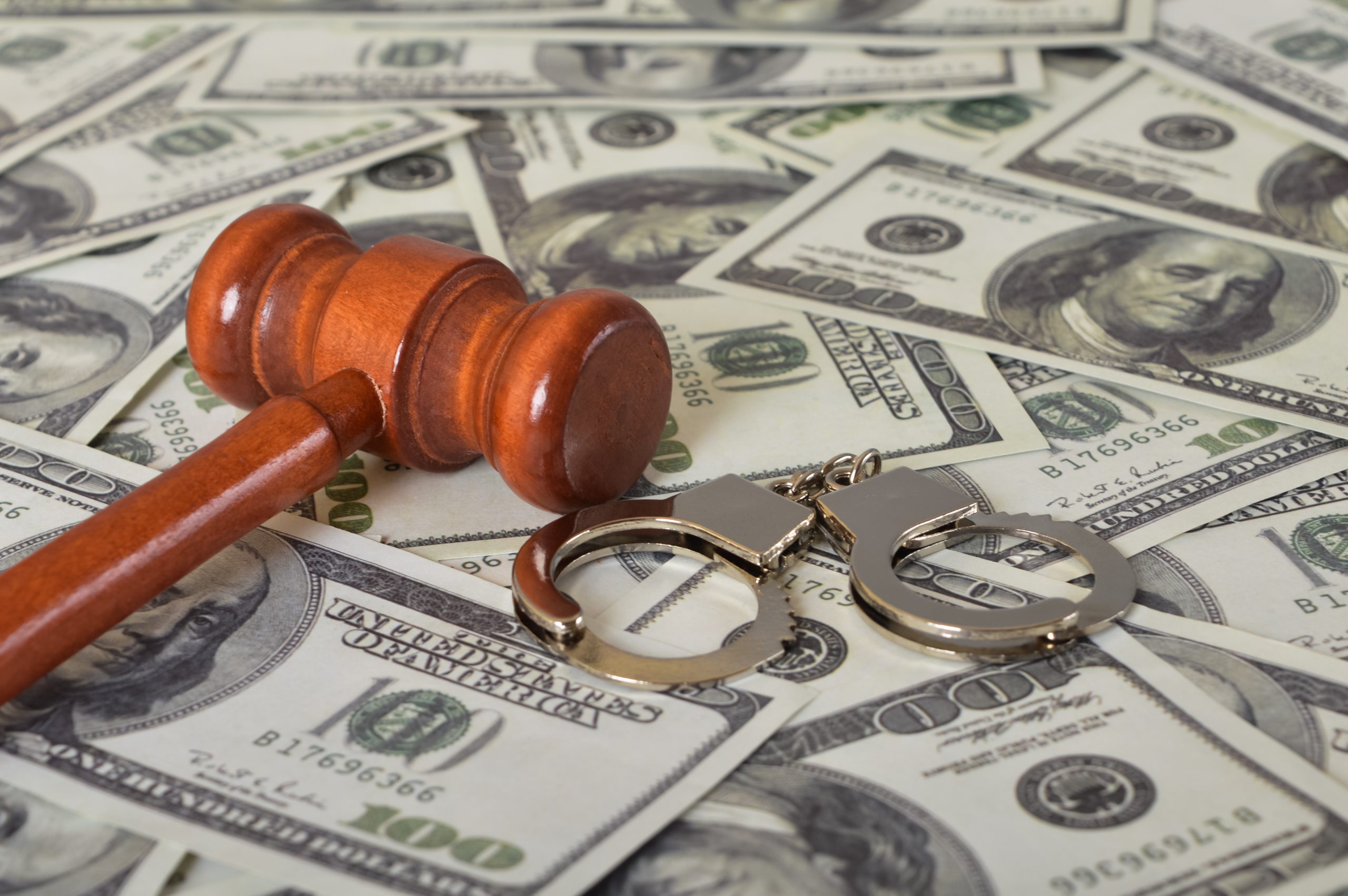 Gavel and handcuffs laying on money