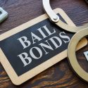Handcuffs lying next to a sign that reads "Bail Bonds," symbolizing arrest and release services.